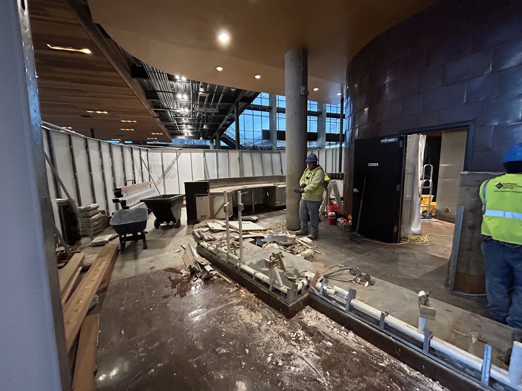 Crews working inside the enclosure on new floor and utilities