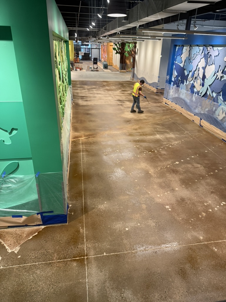 Crew applying treatment to the concrete floor between finished wall features